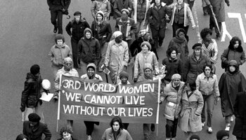march with banner reading "Third World Women: We Cannot Live Without Our Lives"